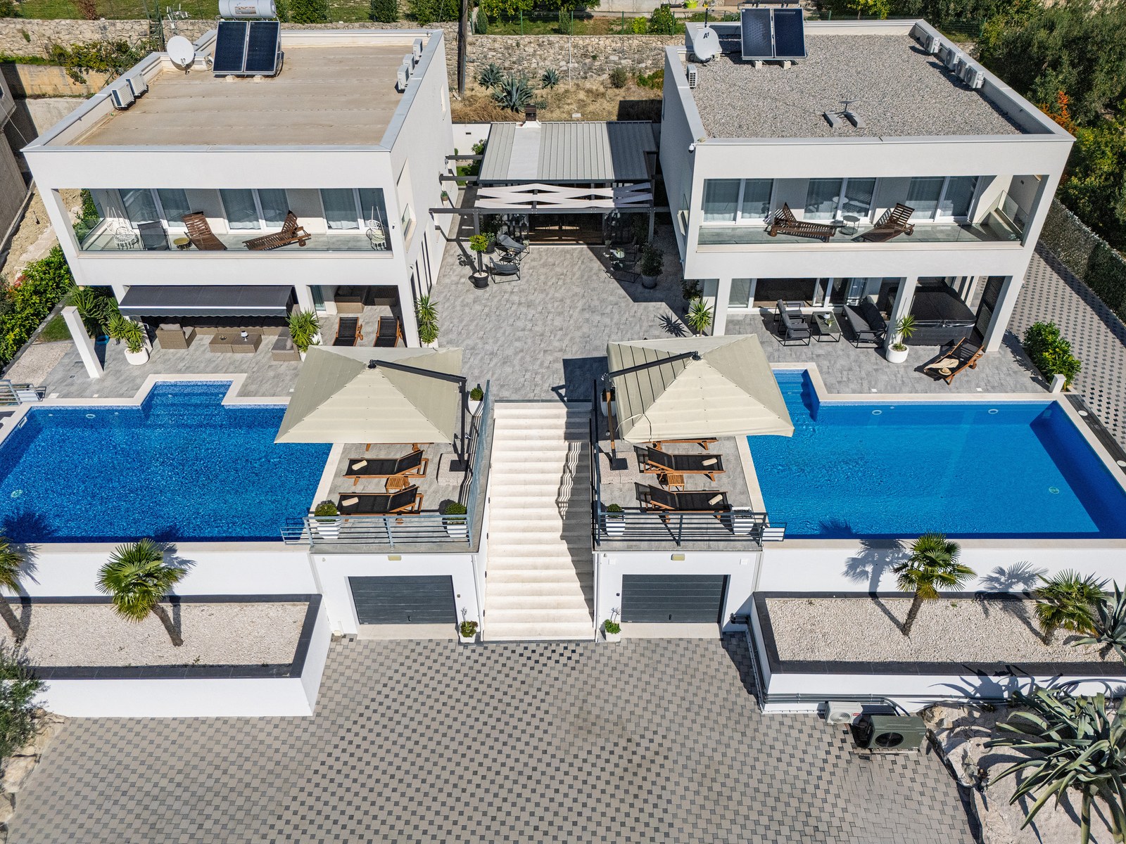 Aerial view of both Villa BlueWave villas, their two private pools and shared central terrace